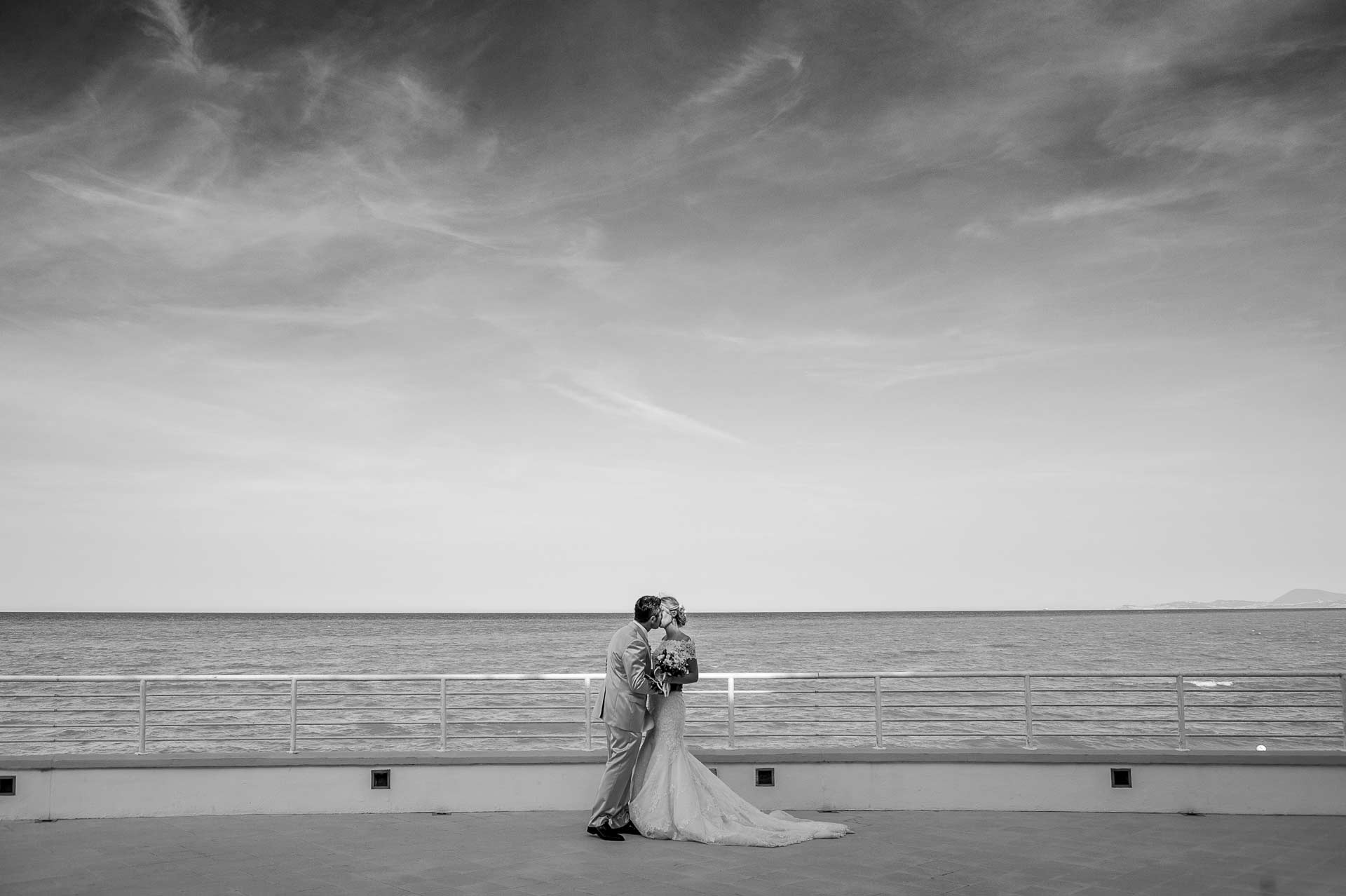 fotografo professionista italia, fotografia di matrimonio bacio sposi al mare